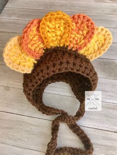 three crocheted hats are sitting on a wooden table with a tag attached to it