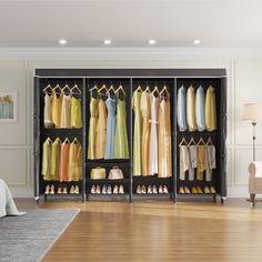 an open closet with clothes and shoes hanging on the rails, in front of a bed