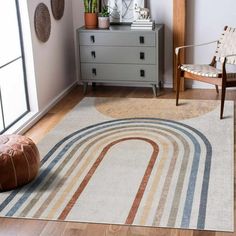 a living room area with a rug, chair and potted plant on the floor