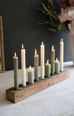 a group of lit candles sitting on top of a wooden stand