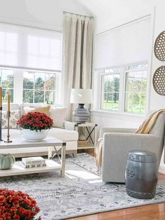 a living room filled with furniture and flowers in vases on top of a coffee table