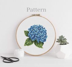 a cross stitch pattern with blue flowers on it