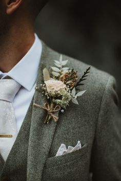 Groom wears rustic pastel rose buttonhole tied with brown string Boho Grooms Boutonniere, Men Buttonhole Wedding, Wedding Button Holes Rustic, Men’s Wedding Flower, Men’s Buttonholes, Boho Beach Wedding Groom, Champagne Wedding Dress With Groom, Enchanted Forest Wedding Groom Attire, Groom Buttoniere Wedding