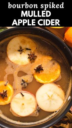 an apple cider with cinnamon spieded on top and sliced apples in the bottom