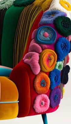 the colorful chair is made out of different colored fabrics and fabric flowers on it's legs