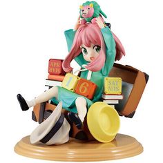 a figurine sitting on top of a pile of books and holding a cat