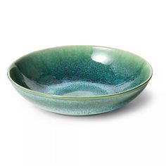 a green bowl sitting on top of a white table