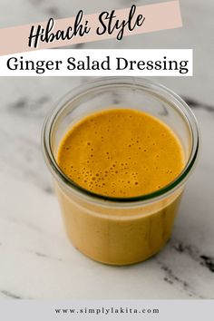 a glass jar filled with ginger dressing sitting on top of a marble counter