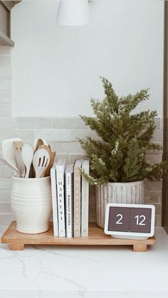 an alarm clock sitting on top of a counter next to books and utensils