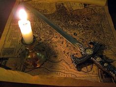 a candle is sitting on top of a map with a cross and knife next to it