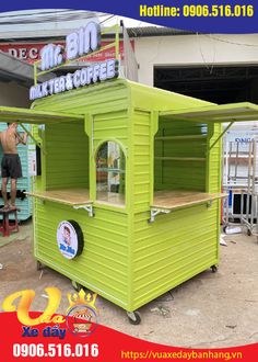 a man standing next to a green food cart