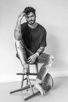 a man sitting on top of a wooden chair