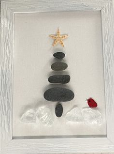 a rock christmas tree with a starfish in the middle and some rocks on top