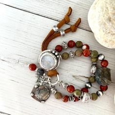 This "Autumn Leaves" Boho chunky bracelet is a vibrant expression of style. The centerpiece is a handmade moonston with a 925 silver artisan button, accompanied by a 925 silver artisan crazy lace agate charm and a protective jehovah 925 silver pendant, 925 silver handmade artisan star charm, barrel beads about 25mm long. Featuring red jasper beads 8mm size, natural unakite beads 8mm size. The intricate design is enhanced with Karen Hill Tribe fine silver beads and links, all beautifully tied tog Bohemian Beaded Bracelets With Moonstone, Bohemian Moonstone Bracelets With Round Beads, Bohemian Moonstone Bracelets With Gemstone Beads, Bohemian Beaded Moonstone Bracelets, Bohemian Moonstone Bracelet With Gemstone Beads, Bohemian Moonstone Beaded Bracelets, Bohemian Moonstone Gemstone Beads Bracelet, Bohemian Moonstone Gemstone Bracelets, Adjustable Bohemian Moonstone Bracelet