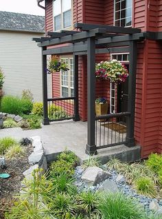 a red house with flowers and plants in the front yard