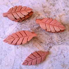 three pieces of wood that have been carved to look like leaves on a stone surface