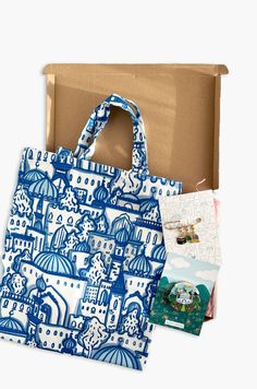 a blue and white tote bag sitting in front of a box with pictures on it