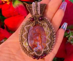 Wire-wrapped red & mauve-colored fancy jasper cabochon with maroon painted accent beads. Wire styles include both heady & weave styles. Wires used are 18g, 20G & 26G antique brass (Artistic Wire brand) and 26G rose-gold plated silver (Artistic Wire brand)**. Pendant size approx. 2.5” X 3" and is relatively lightweight for a pendant of such size. Pendant will arrive strung on an 18” bronze chain*.*If 18” is too short, I can string the pendant on a black cord with a length of your choi Bohemian Burgundy Jewelry As Gift, Bohemian Burgundy Jewelry Gift, Artisan Wire Wrapped Red Jewelry, Artisan Red Wire Wrapped Jewelry, Jasper Cabochon Jewelry For Gifts, Jasper Cabochon Jewelry Gift, Cabochon Jasper Jewelry As Gift, Artisan Red Jasper Jewelry, Unique Red Jasper Necklaces