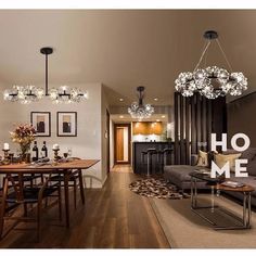 a living room filled with furniture and a chandelier hanging over the top of it