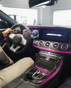 the interior of a mercedes car with pink lights