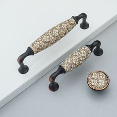 two decorative handles and knobs on a white surface