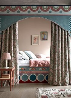 a bed sitting under a window next to a wooden table