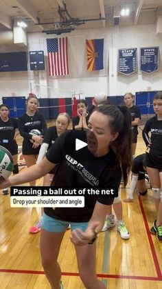 a group of young women standing on top of a gym floor holding volleyball balls in their hands