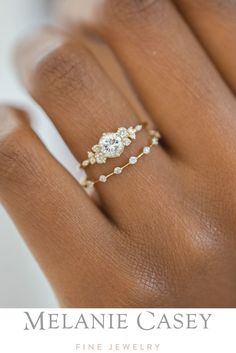 a woman's hand with a diamond ring on top of her finger and the words melanie casey fine jewelry