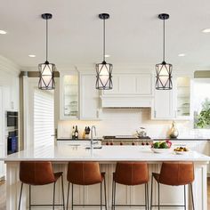 a kitchen island with four stools in front of it