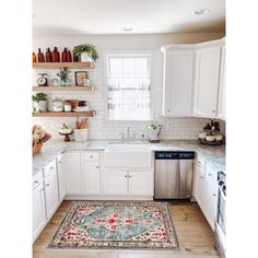 a kitchen with white cabinets and an area rug