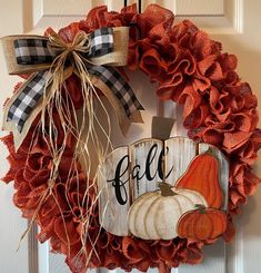 a fall wreath with pumpkins and burlocks hanging on the front door handle