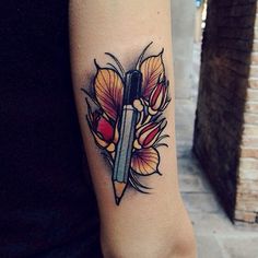 a woman's arm with a knife and flower tattoo on the left side of her arm