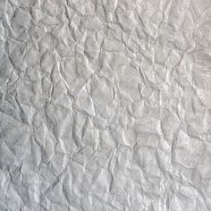 an old white paper textured with small cracks and crinkled edges is seen in this image