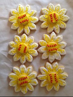 some yellow and white decorated cookies are laying on a tablecloth with red trimmings