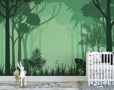 a baby's room with a green forest wall mural