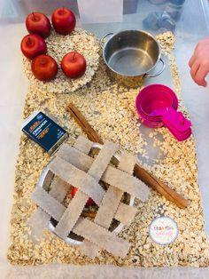 an apple pie sits on a table surrounded by other food items and utensils