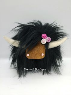 a stuffed animal with long hair and flowers on it's head