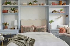 a white bed sitting in a bedroom next to a wall filled with bookshelves