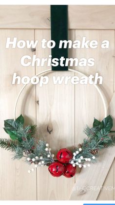 a christmas wreath hanging on the side of a wooden door with holly and red bells