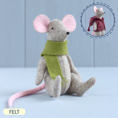 a stuffed mouse with a green scarf around it's neck next to a toy rat