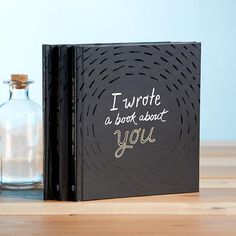 a book sitting on top of a wooden table next to a bottle