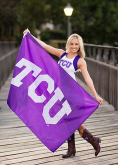 a woman is holding a purple flag on a bridge