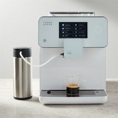 an espresso machine sitting next to a coffee cup