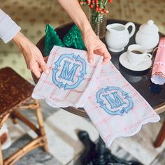 two people are holding towels with the letters n and m on them while sitting at a table