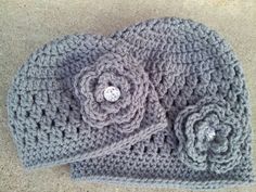 a crocheted hat with a flower on the front and a button in the middle