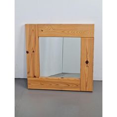 a wooden frame with a mirror on the top and bottom part in front of it