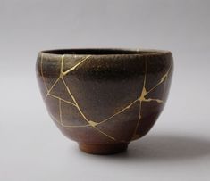 a brown bowl with gold lines on it