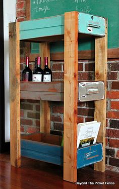 a wooden shelf with wine bottles on it in front of a chalkboard and brick wall