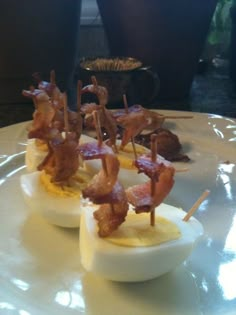 deviled eggs with bacon on them are sitting on a plate