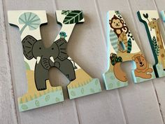 the letters are made out of wood and have animals on them, including an elephant